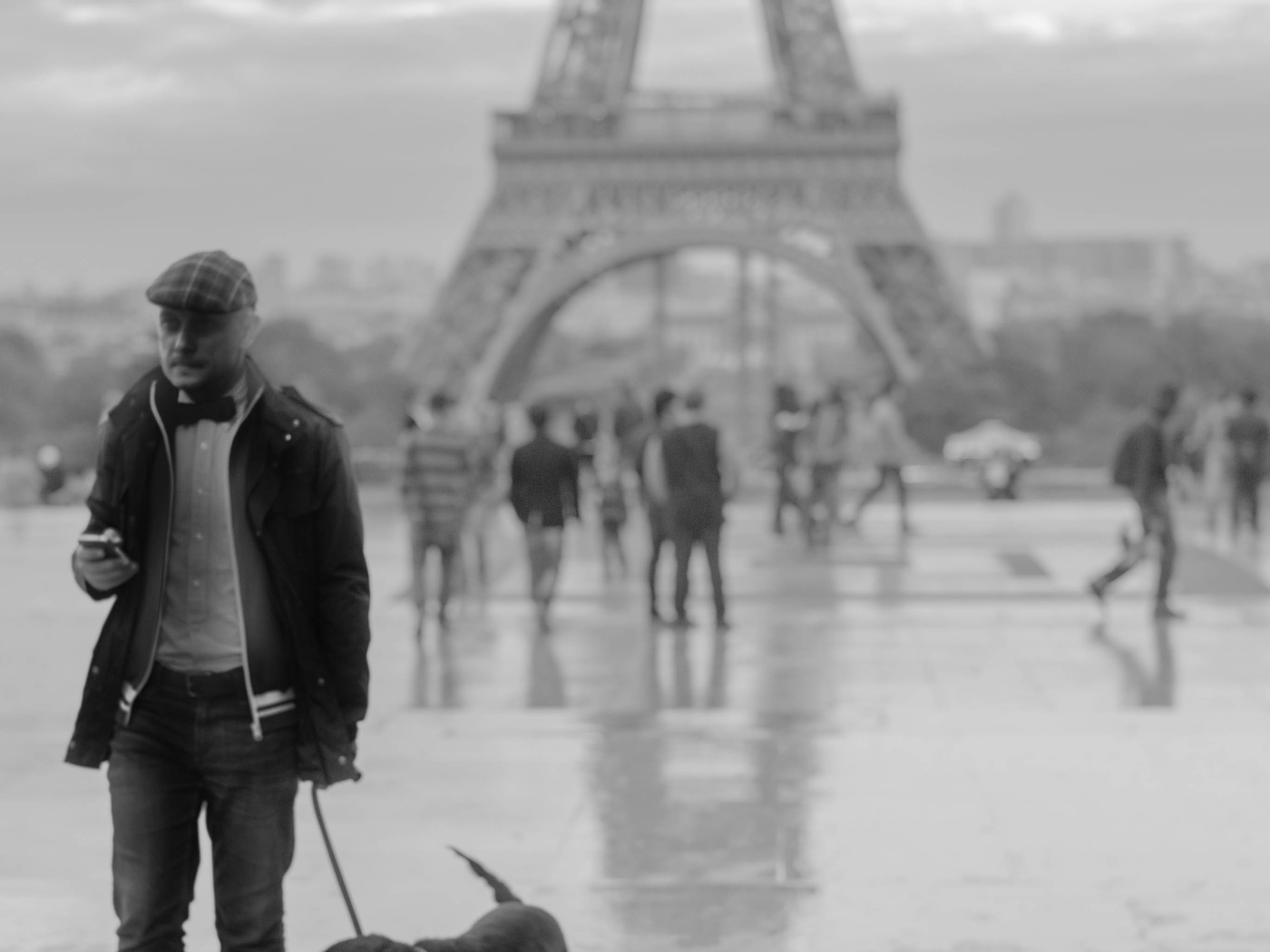Человек с собакой возле Эйфелевой башни, чёрно-белое фото