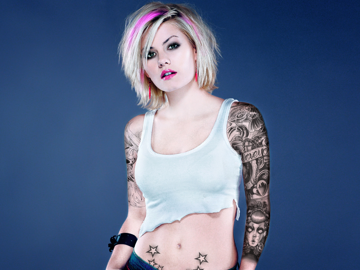 Девушка бунтарка с татуировками на руке и животе