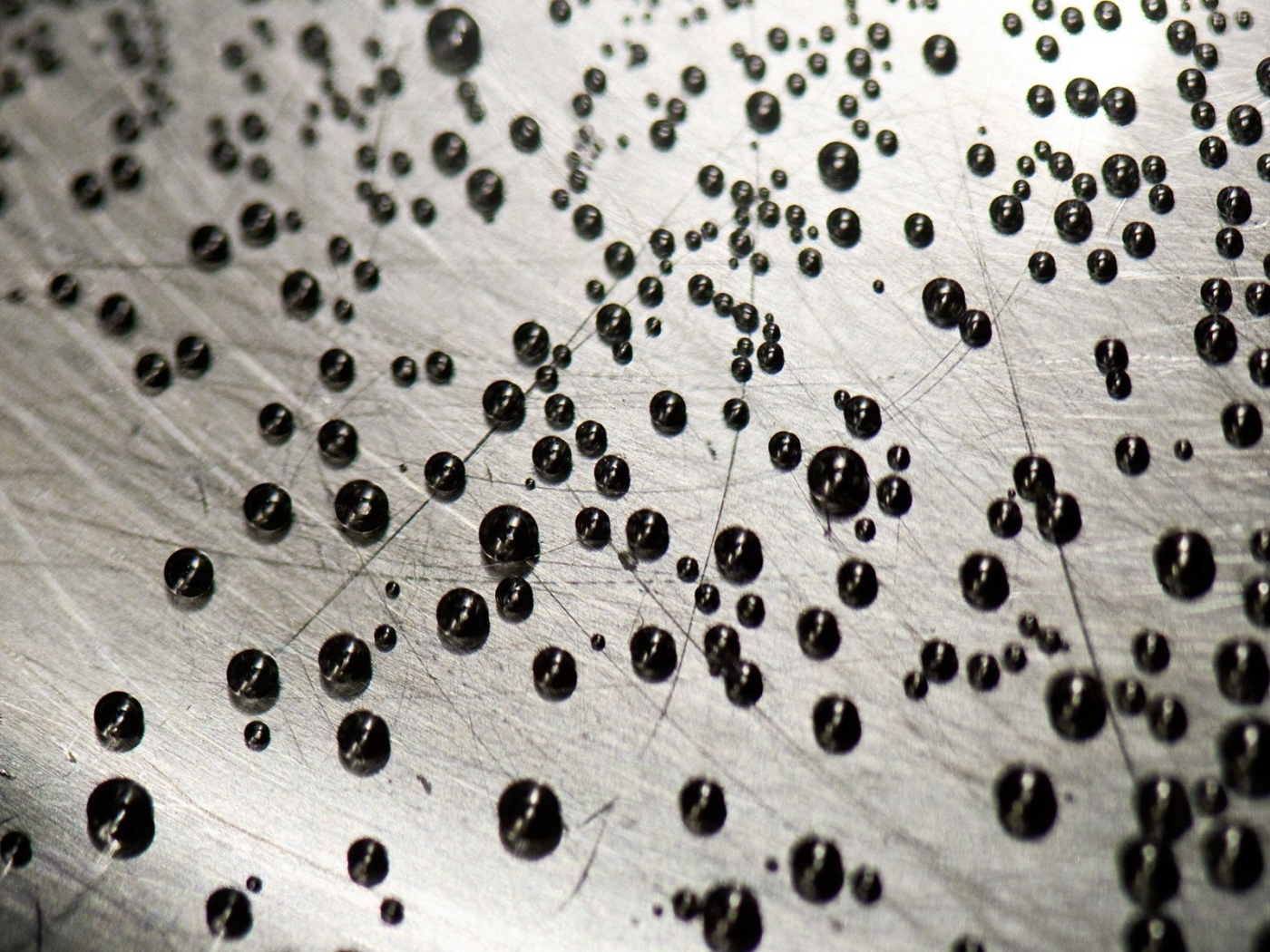 Мелкие черные шарики на серой поверхности