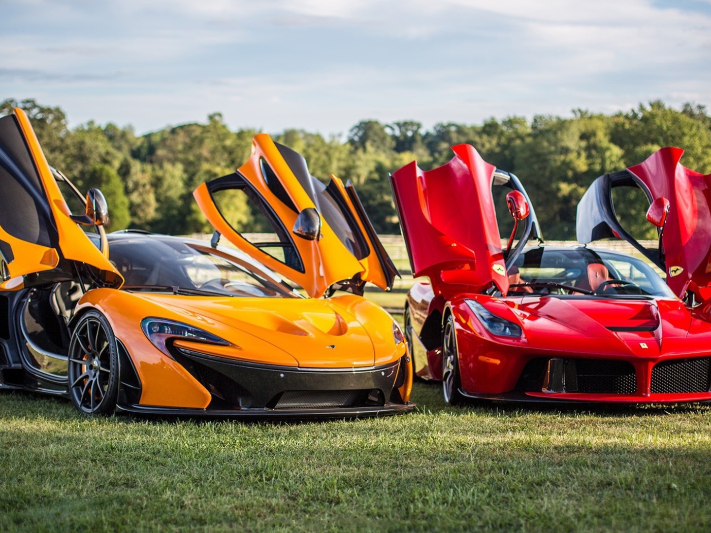 Красный Ferrari LaFerrari и оранжевый Макларен на газоне