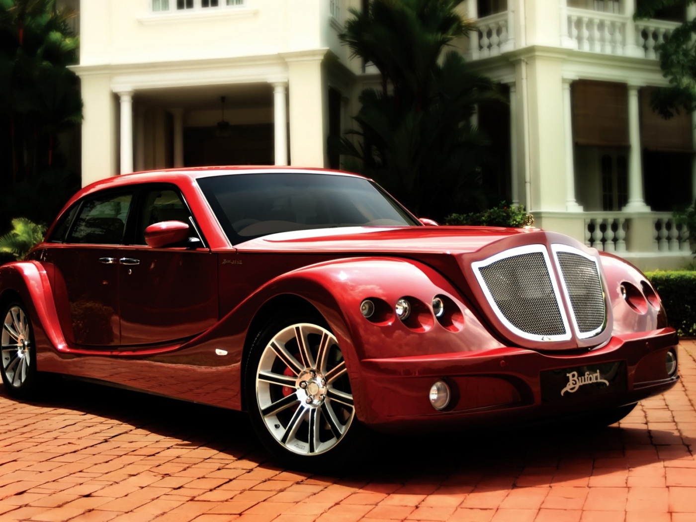 Красный роскошный автомобиль на мощеной дорожке