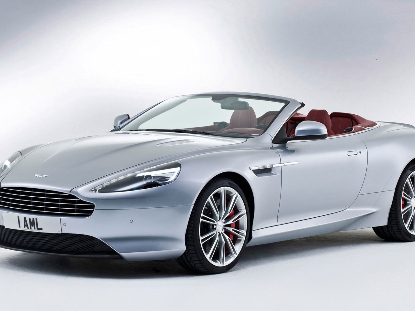 Серебристый кабриолет Aston Martin на белом фоне
