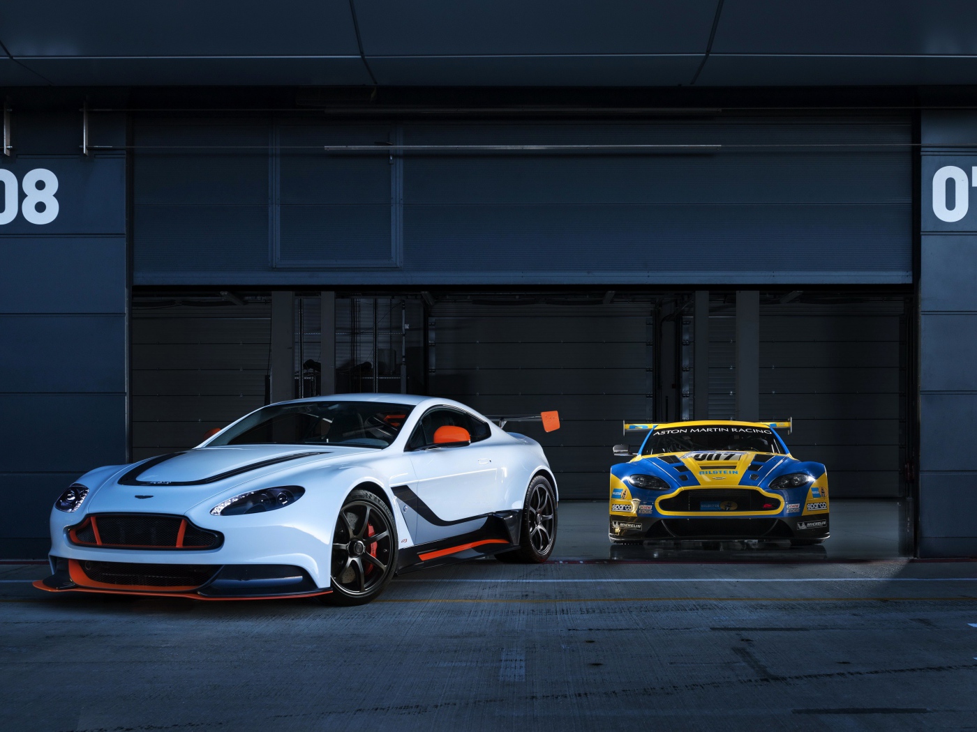 Два авто Aston Martin выезжают из гаража