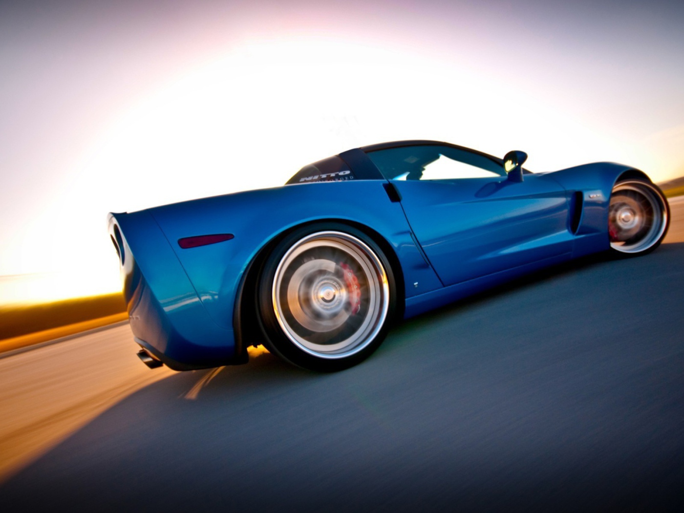 Синий Chevrolet Corvette быстро едет по пустыне