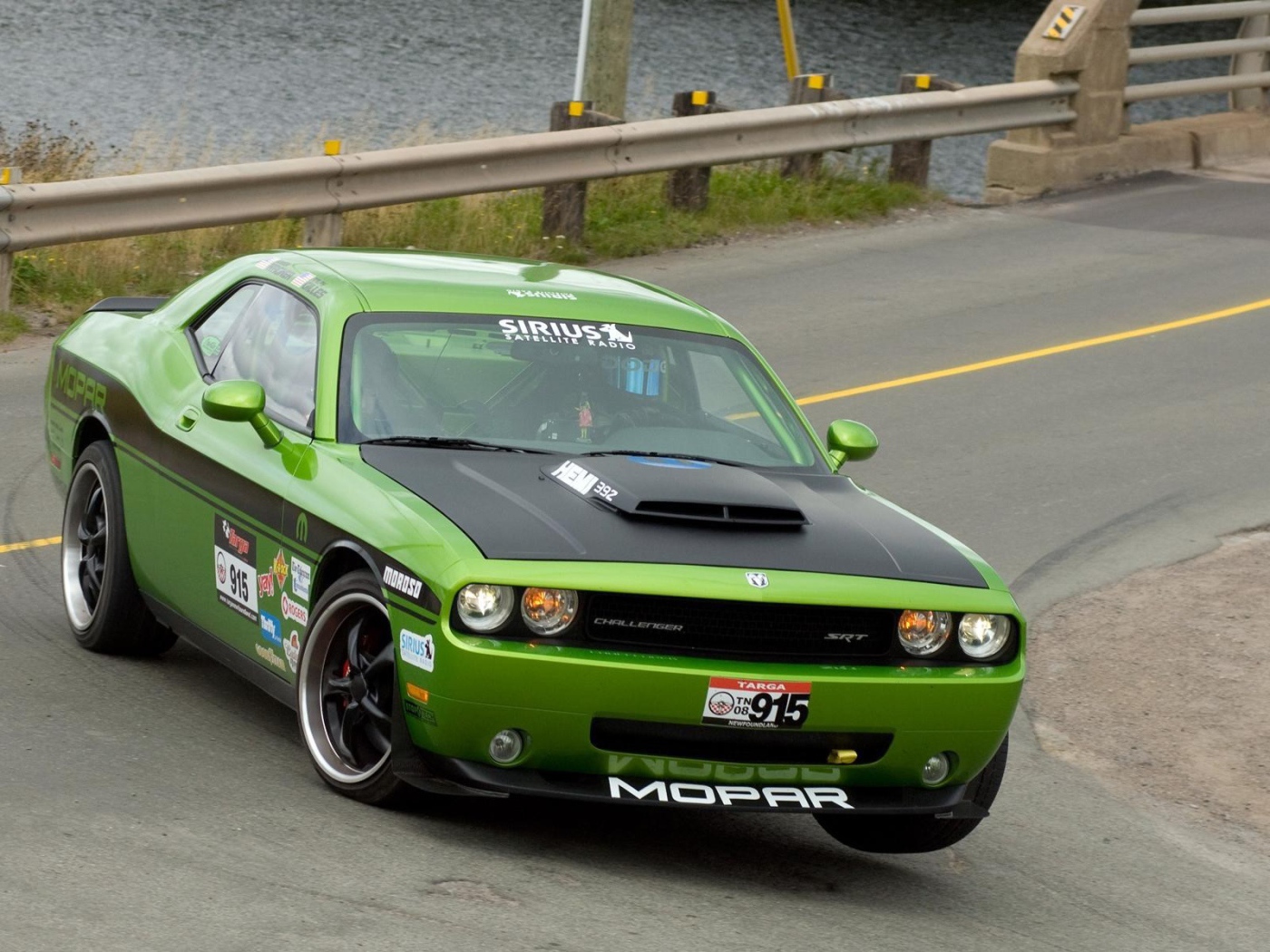 Зеленый автомобиль Dodge Challenger SRT8 на повороте