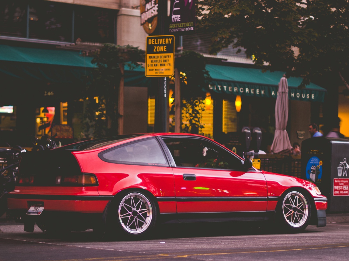 Красная Honda CRX стоит у уличного кафе