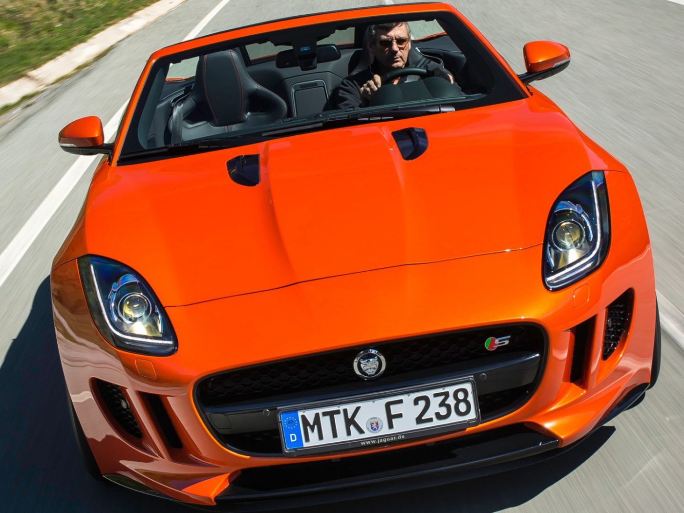 Оранжевый Jaguar F-Type на шоссе
