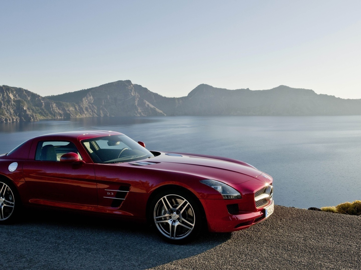 Красный Mercedes SLS на берегу озера