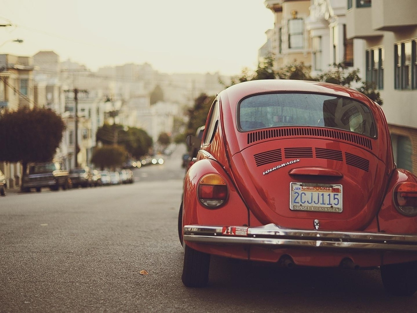 Красный Volkswagen Beetle припаркован на краю улицы