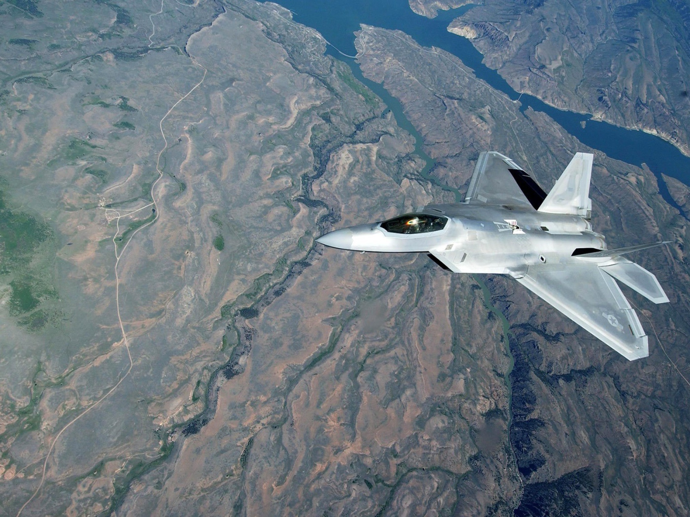 Самолет F-22 Raptor над поверхностью земли