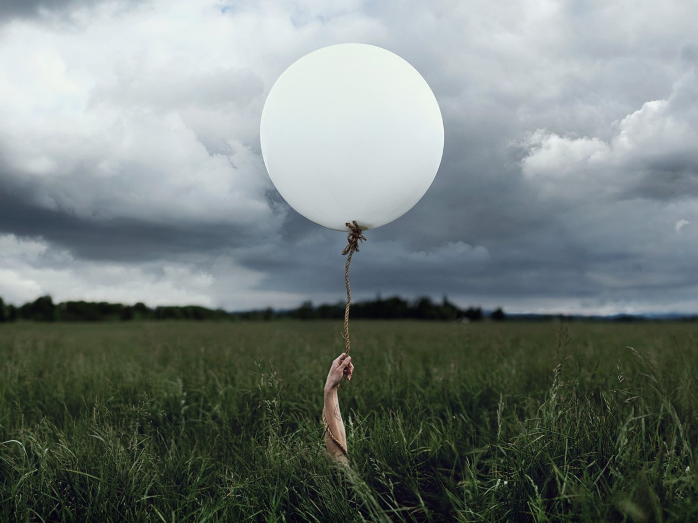 Рука с шаром среди поля