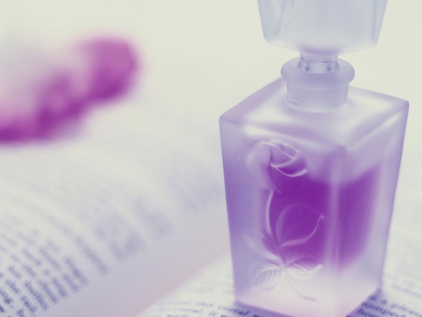 Флакон духов на открытой книге