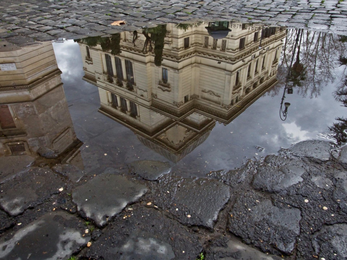 Отражение городского здания в луже