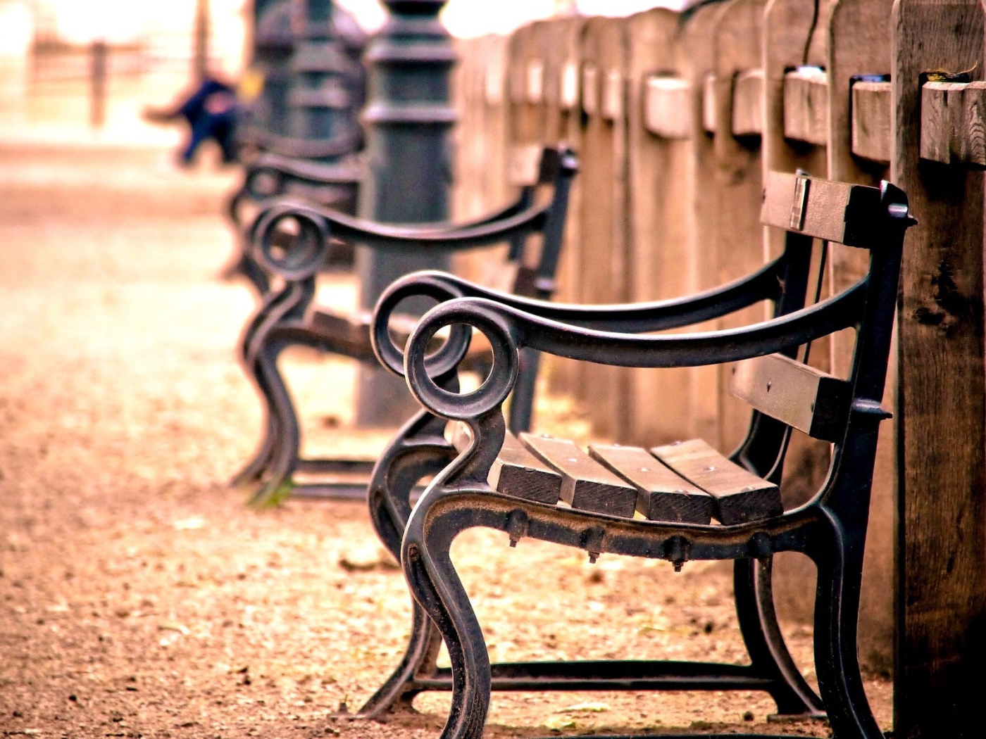 Кованые скамьи у деревянного забора