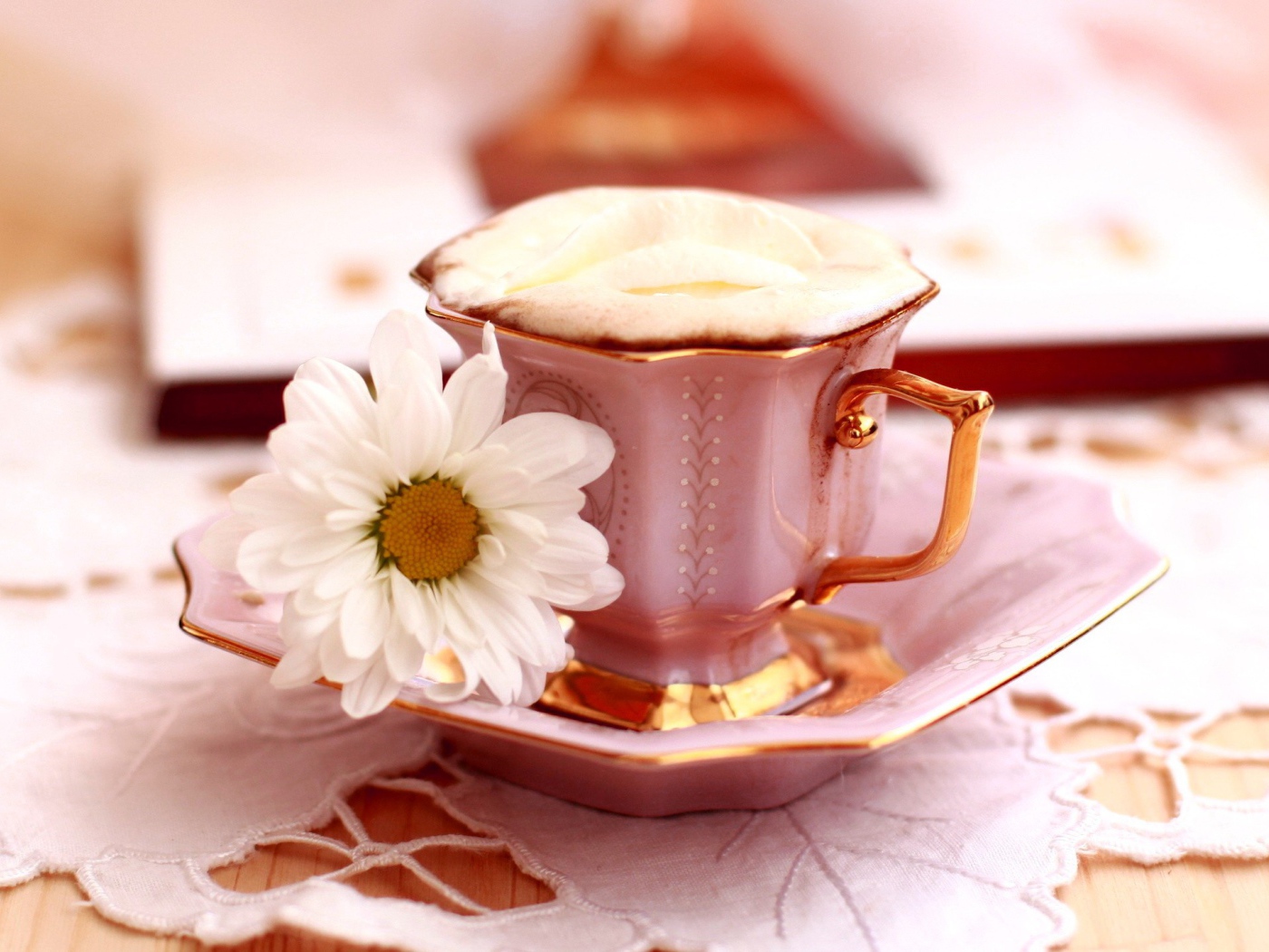 Кофе с пенкой и ромашка на блюдце