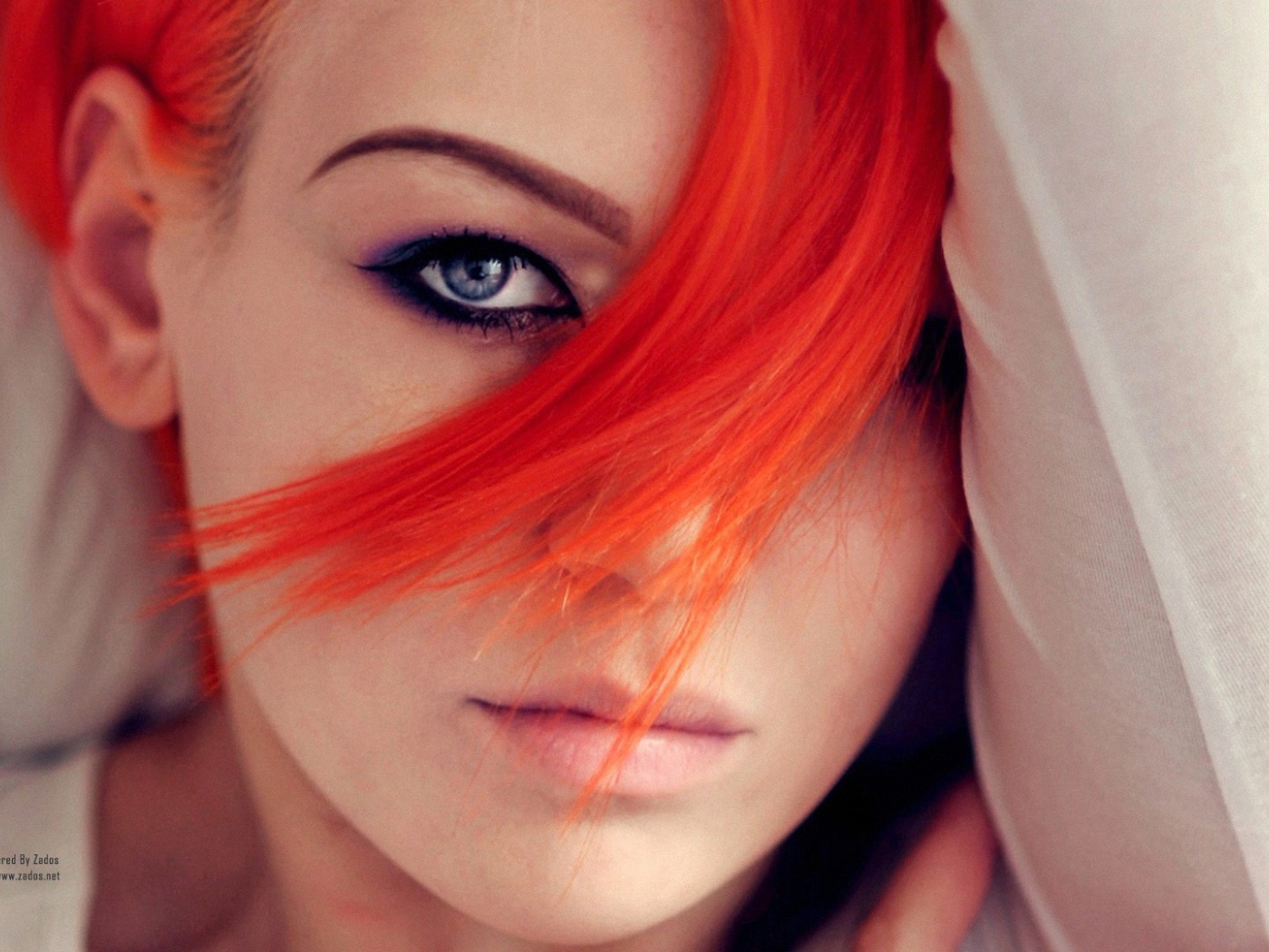 Прядь оранжевых волос на лице у девушки