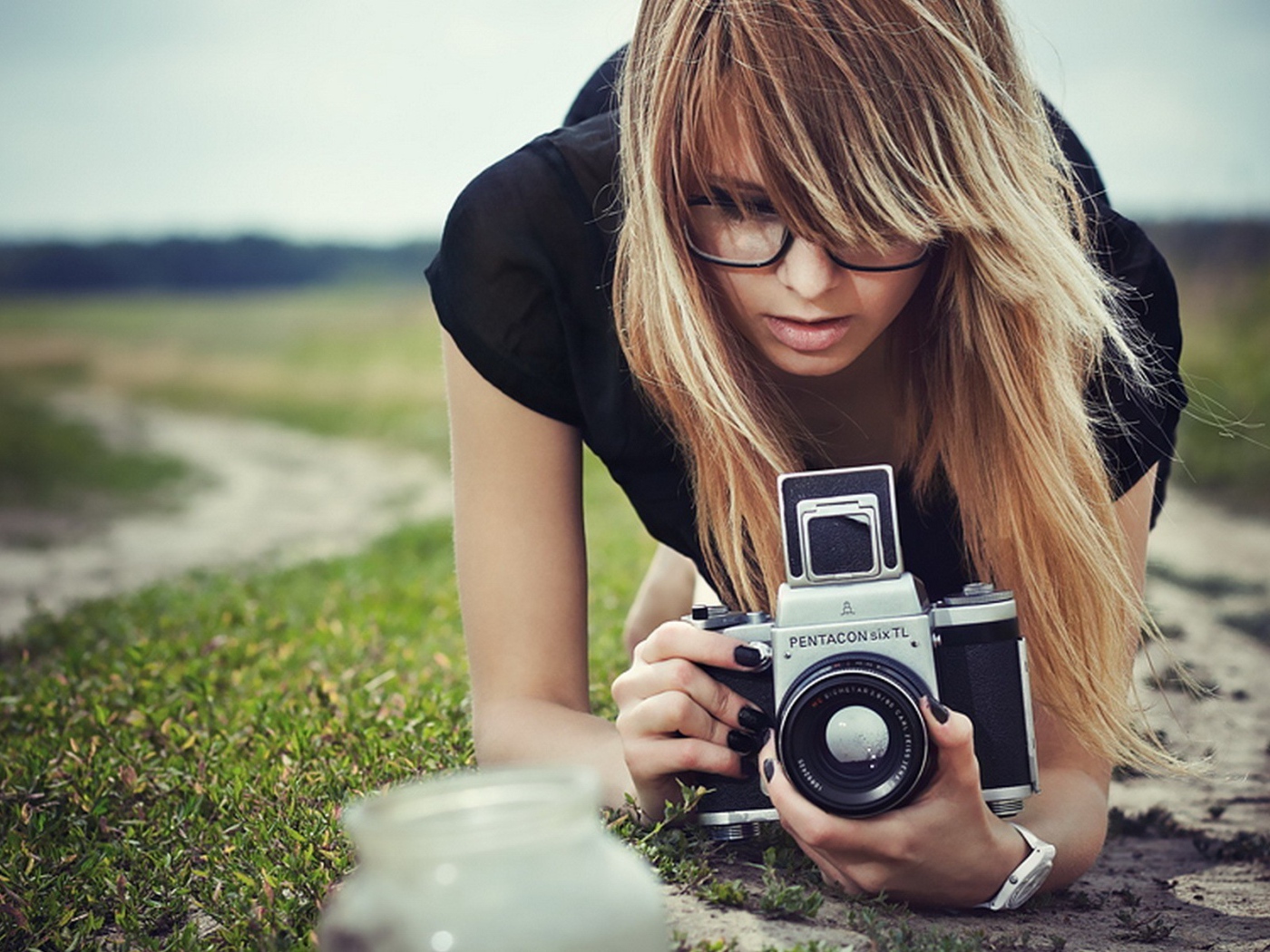 Девушка в очках фотографирует траву
