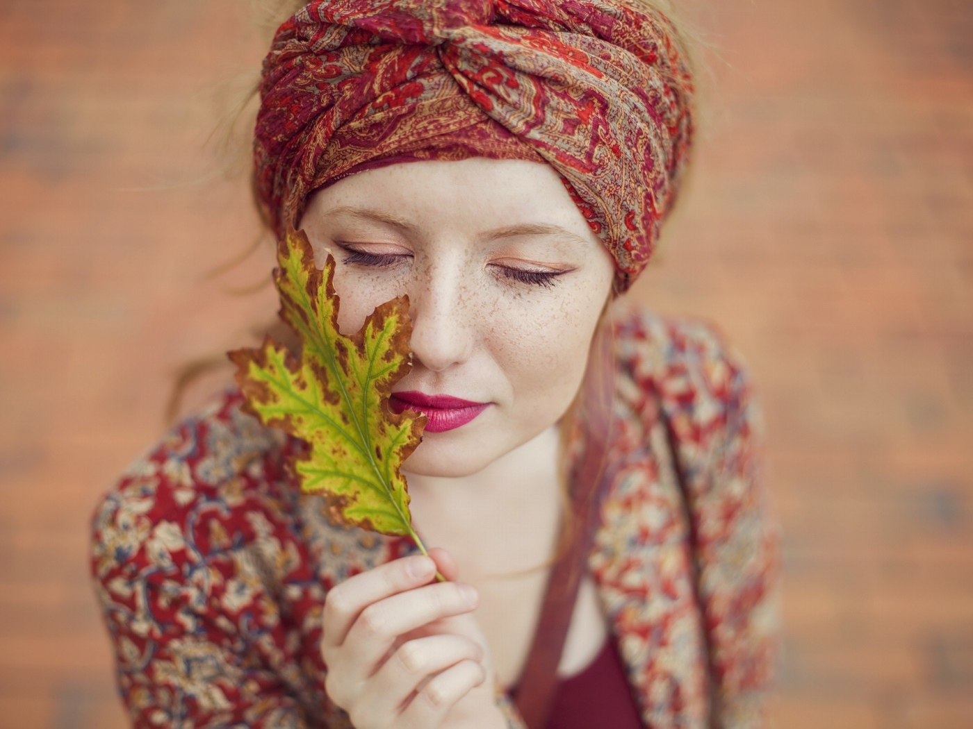 Девушка в традиционном наряде держит в руке лист