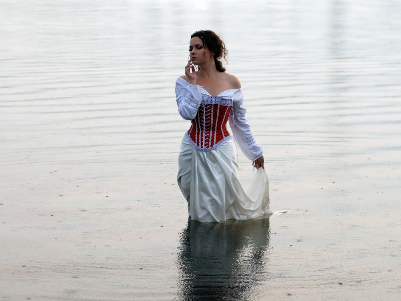 Девушка в белом платье стоит в воде