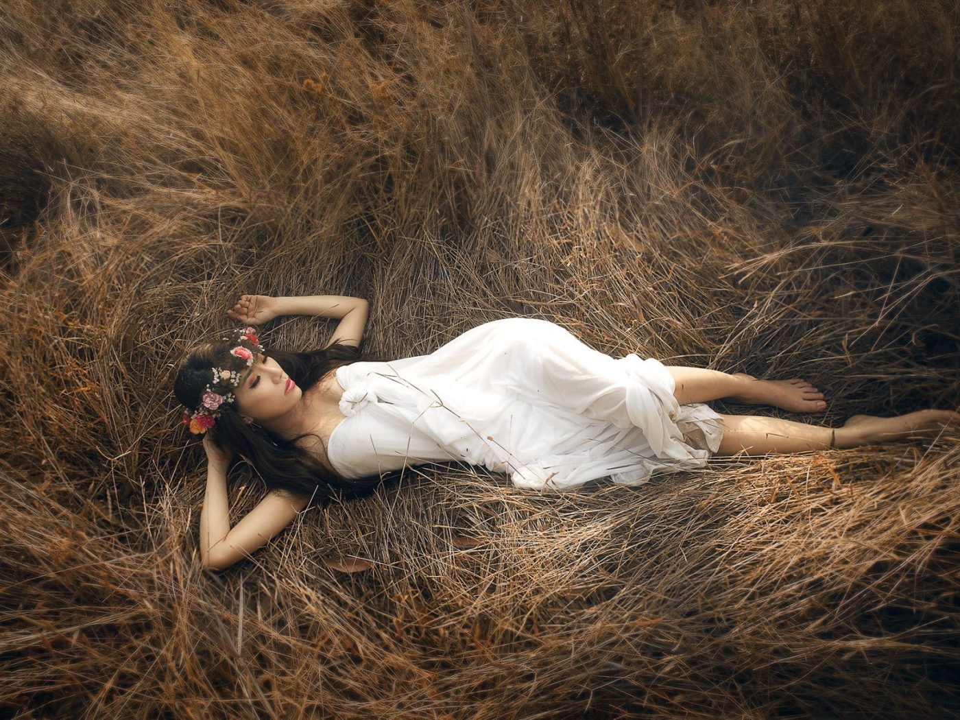 Девушка лежит на сухой траве