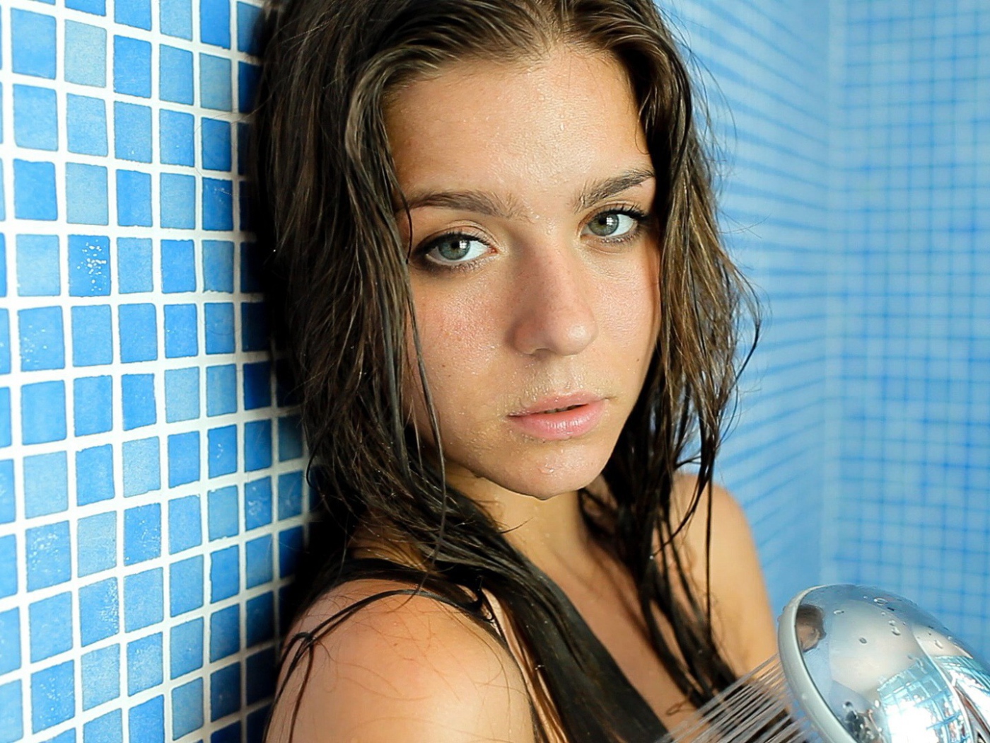 Зеленоглазая брюнетка стоит в душе