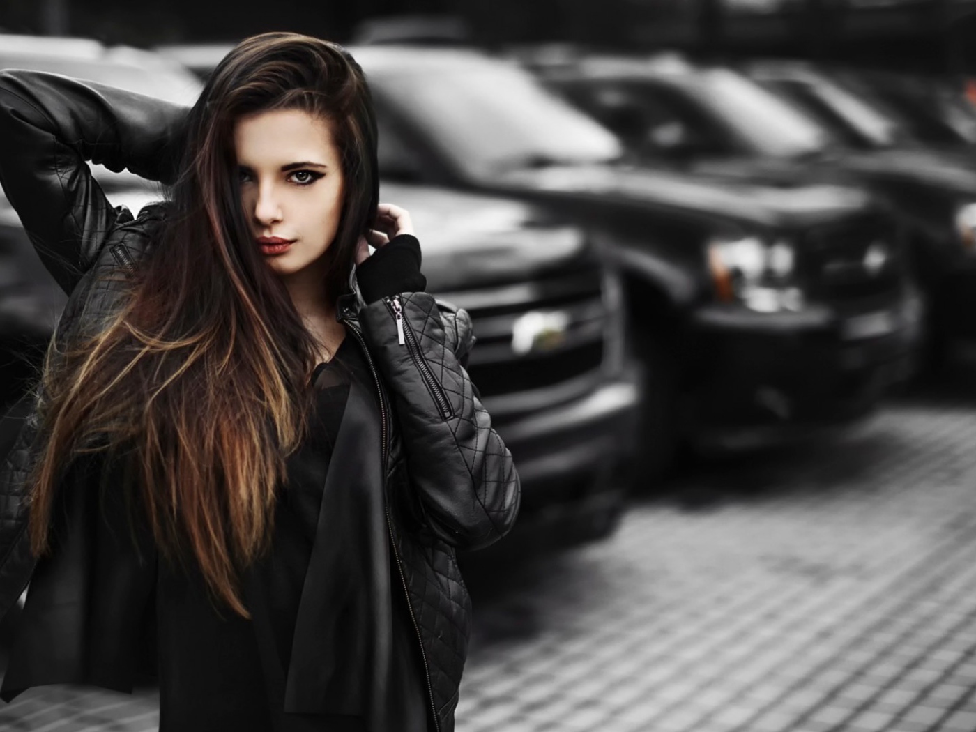 Черноволосая девушка на фоне черных автомобилей