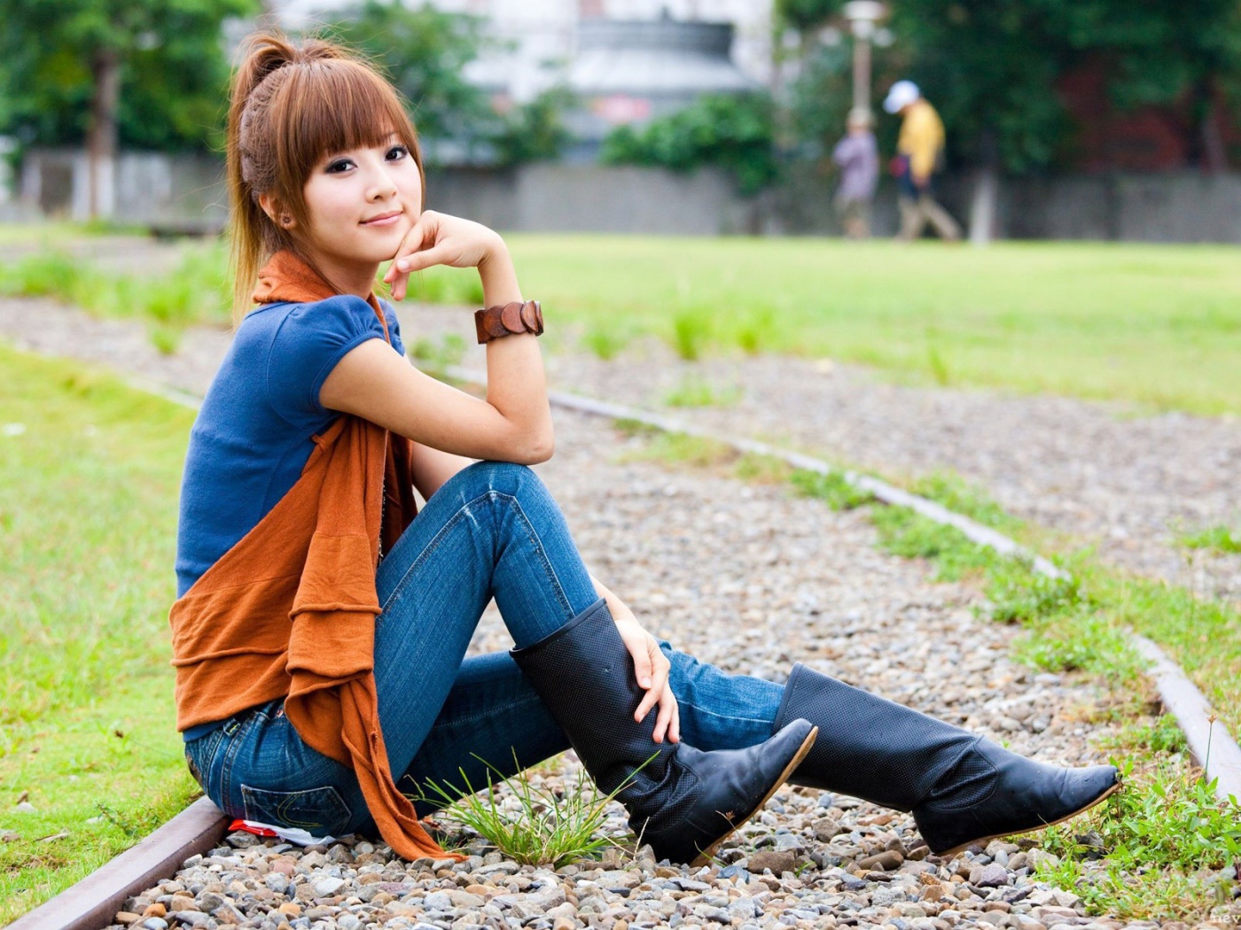 Японская девушка сидит на трамвайном пути