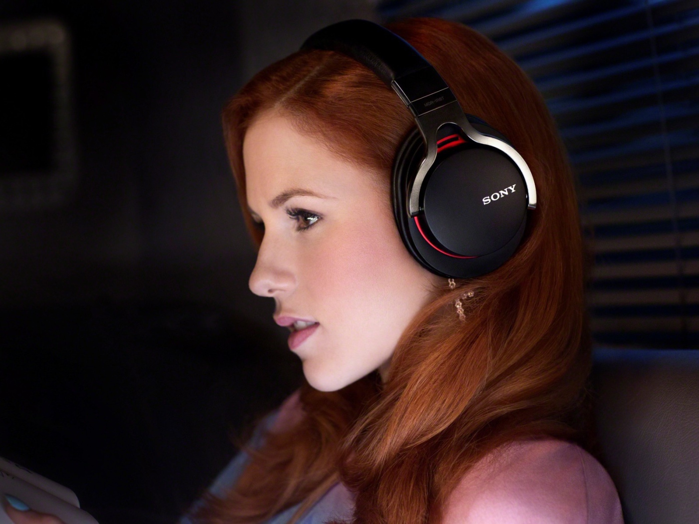 Рыжеволосая девушка слушает музыку