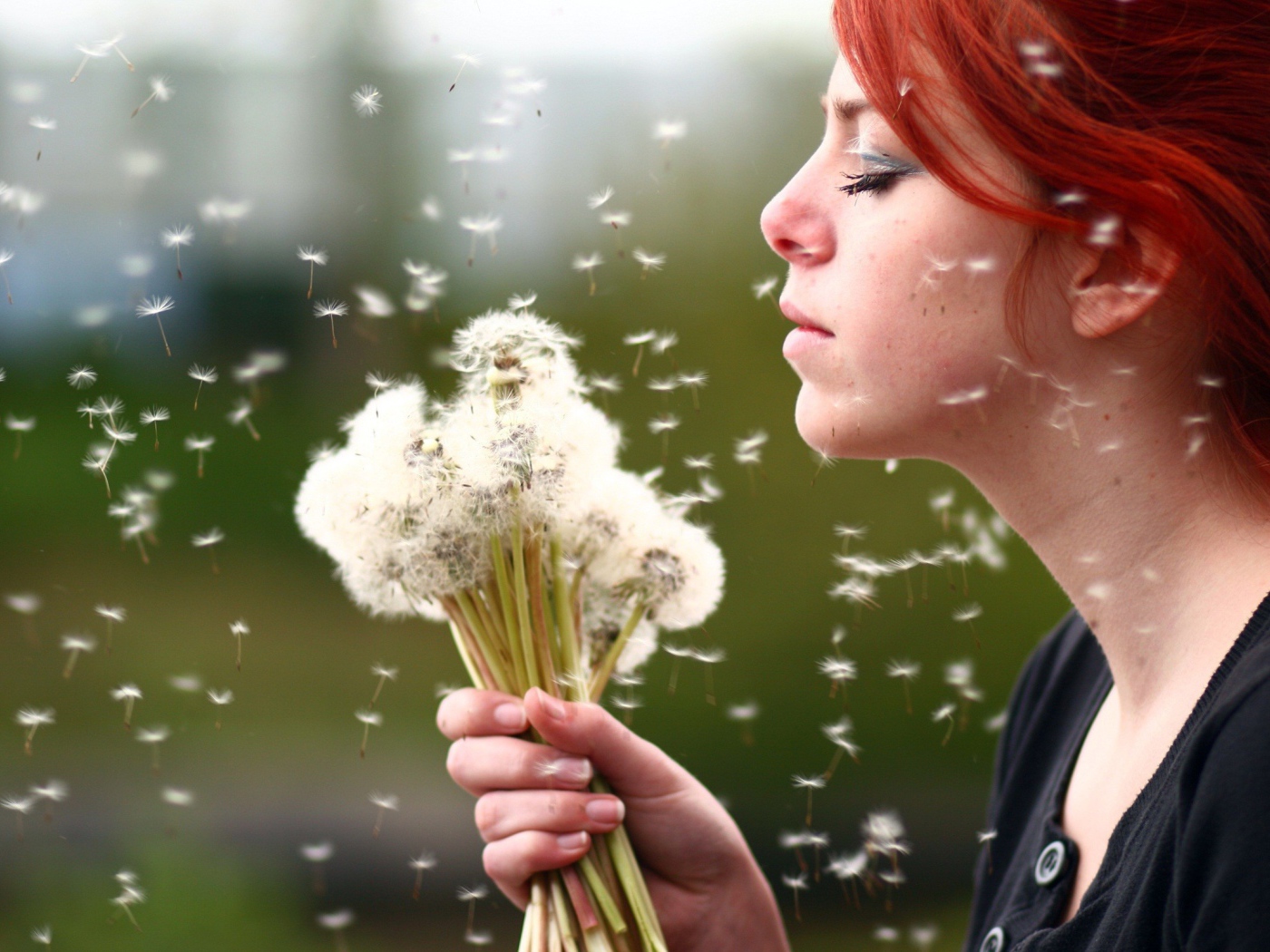 Рыжая девушка с букетом зрелых одуванчиков