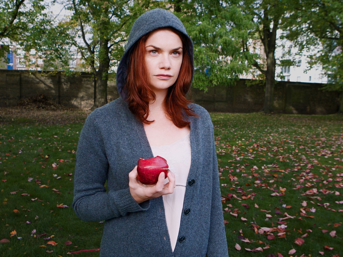 Девушка в капюшоне с яблоком