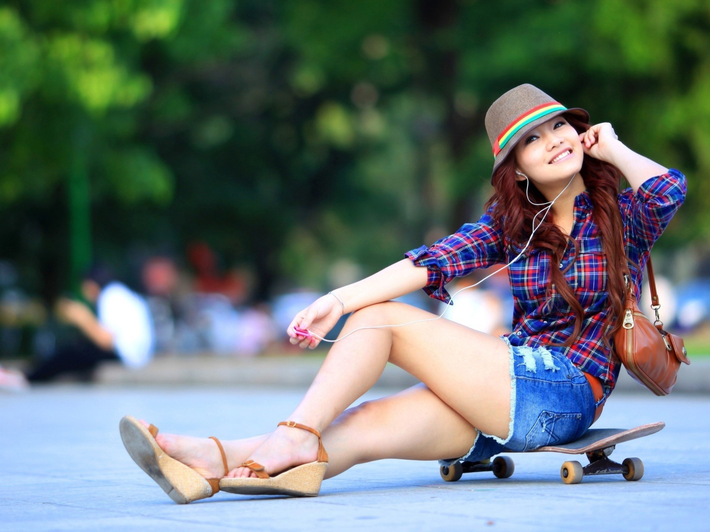 Девушка сидит на скейтборде