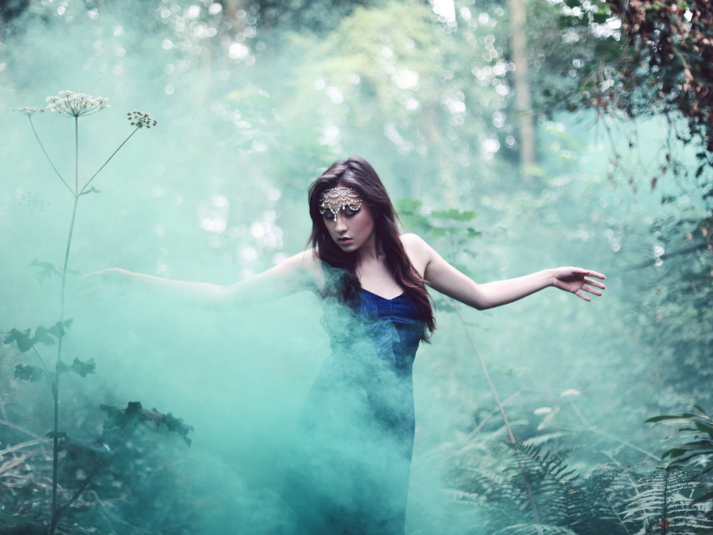 Девушка идет среди дыма по лесу