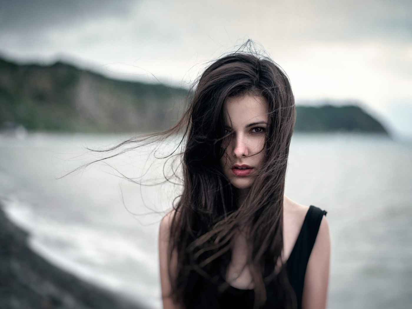 Ветер треплет волосы девушки у моря, портрет
