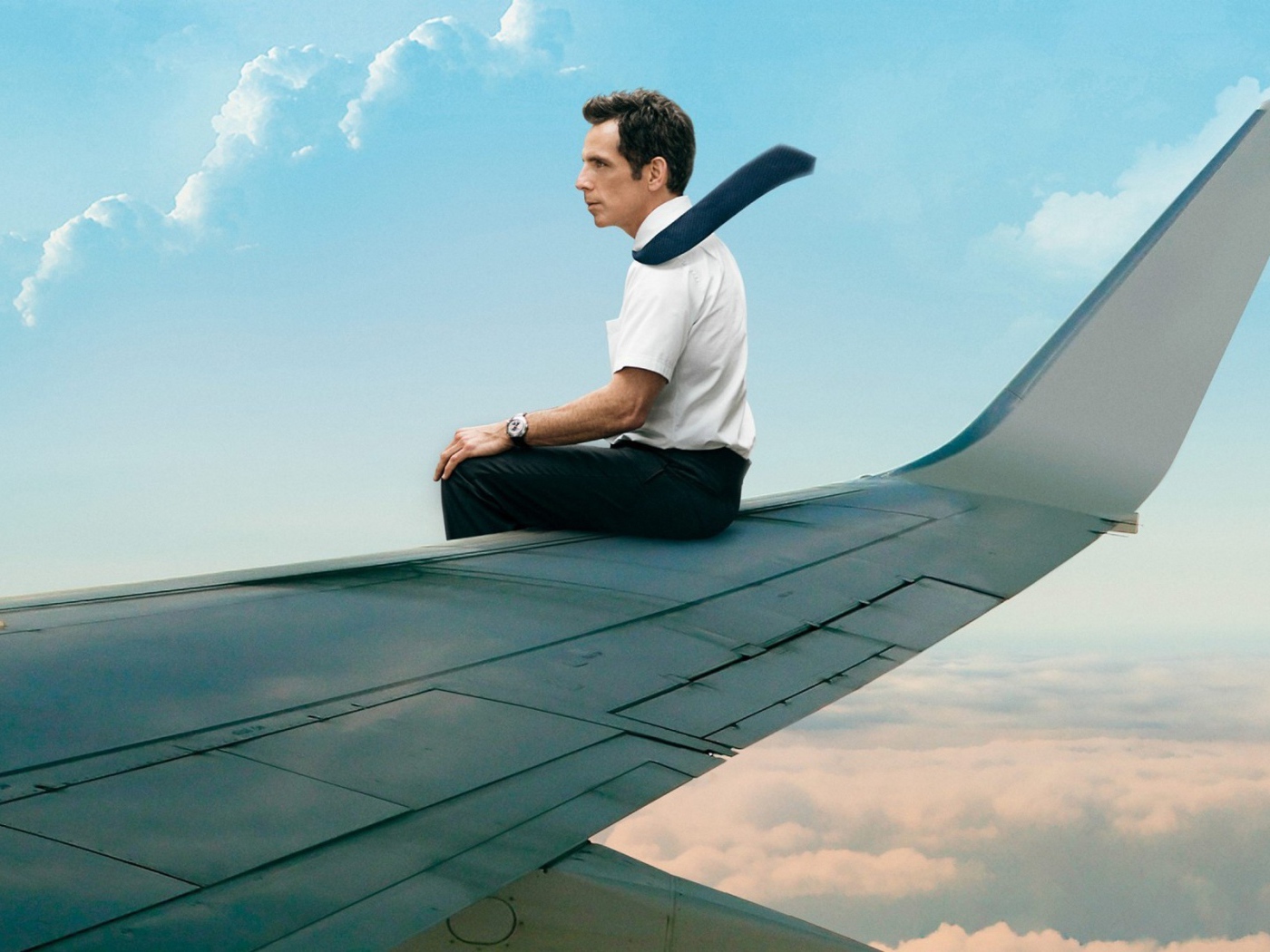 Мужчина сидит на крыле самолета