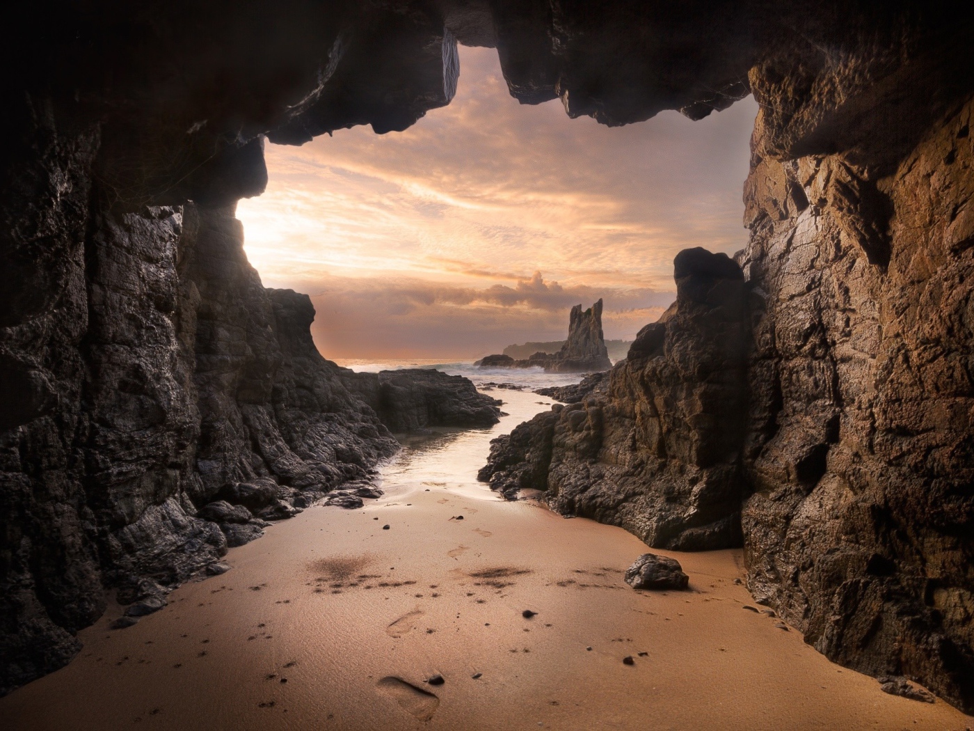 Мокрый песок у входа в пещеру