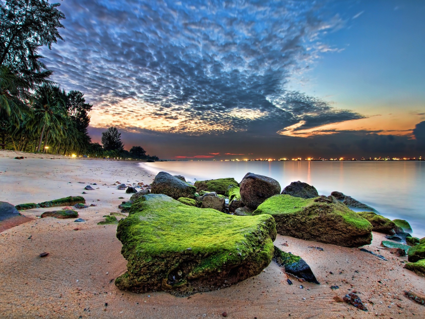 Зеленые камни на песке пляжа