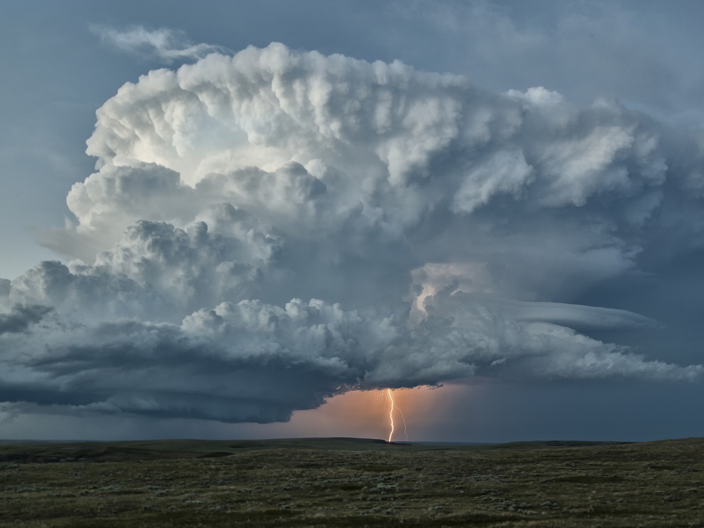 Оранжевая молния в огромном белом облаке