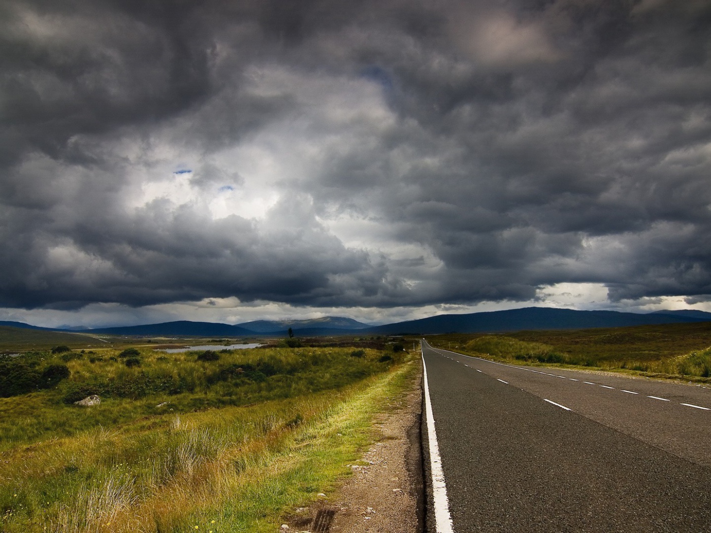 Шоссе среди полей под мрачными облаками