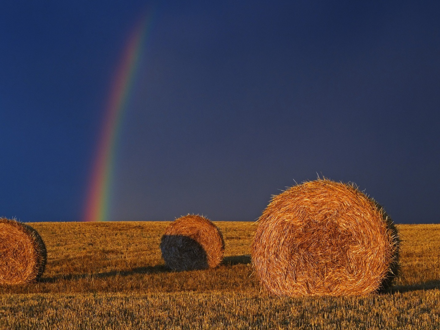 Радуга позади убранного поля