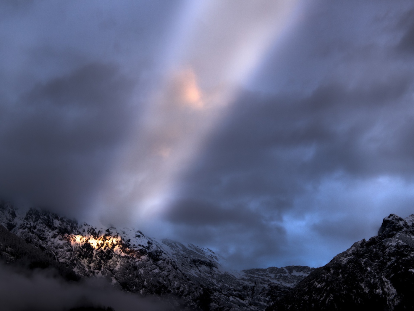 Луч солнца среди облаков в горах