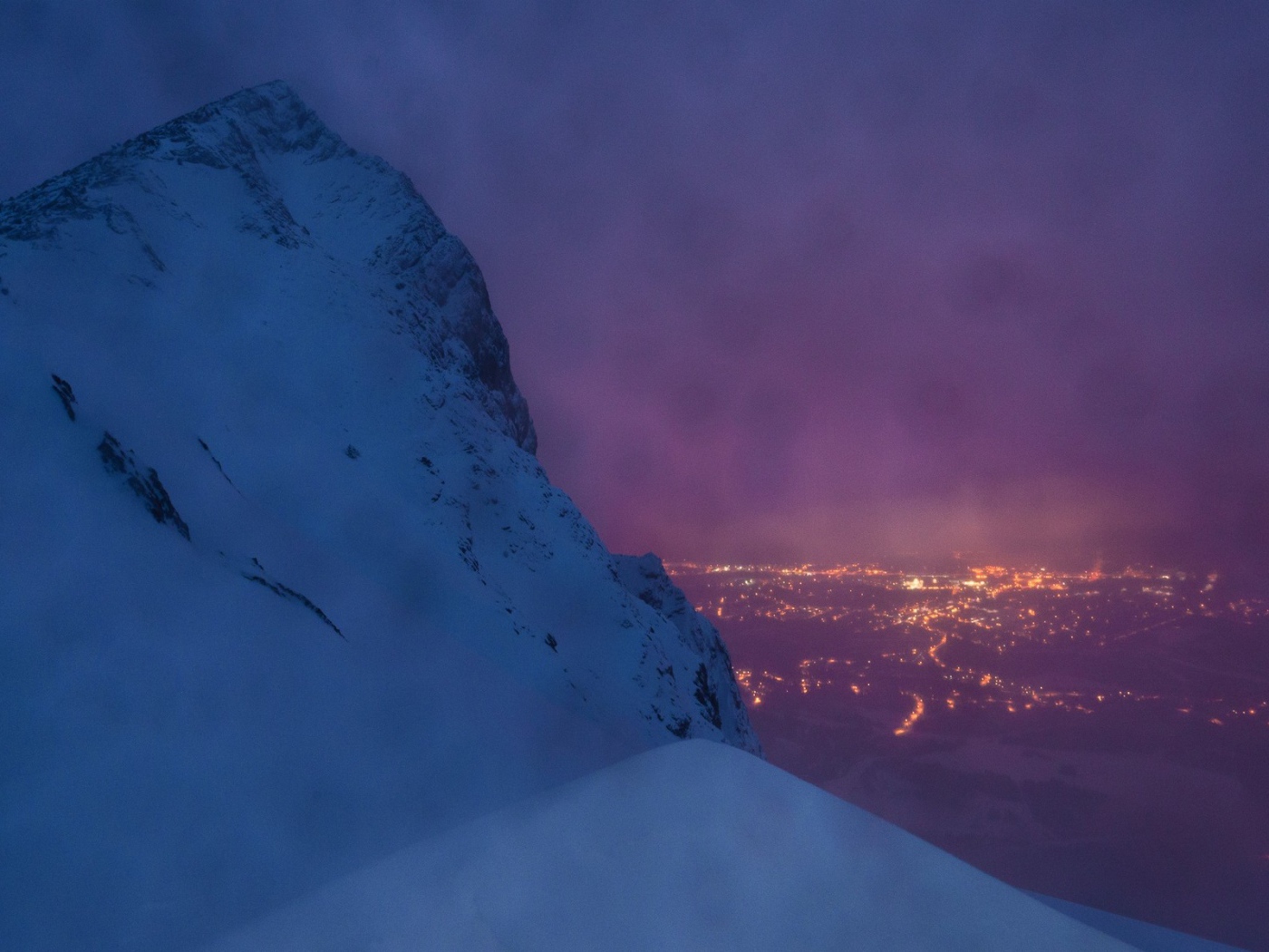 Заснеженная скала на фоне ночного города