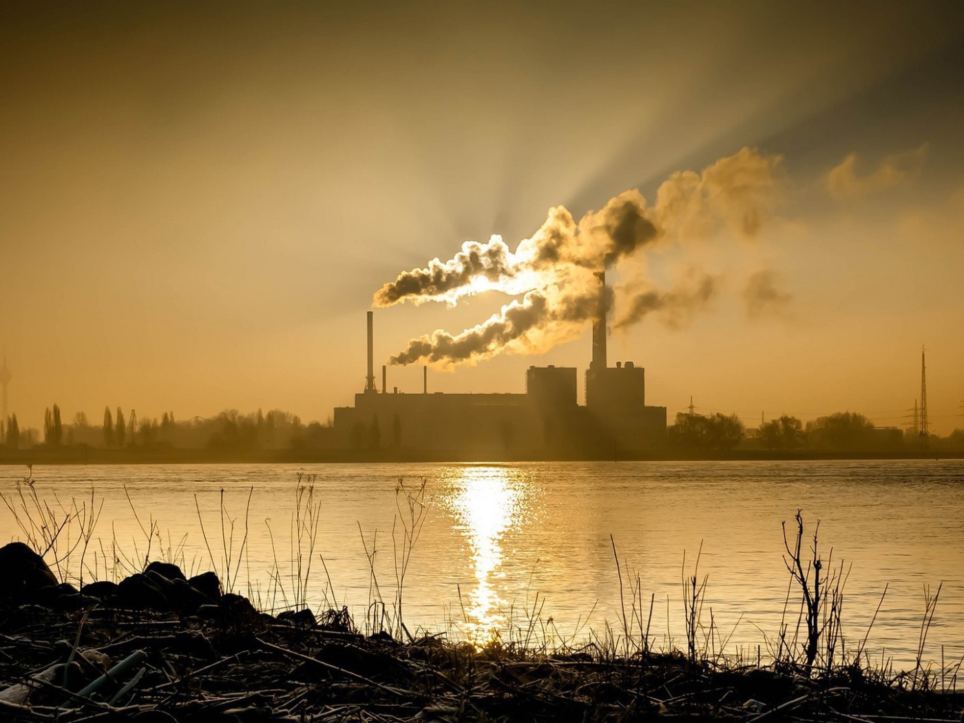 Лучи солнца пронизывают дым из заводских труб