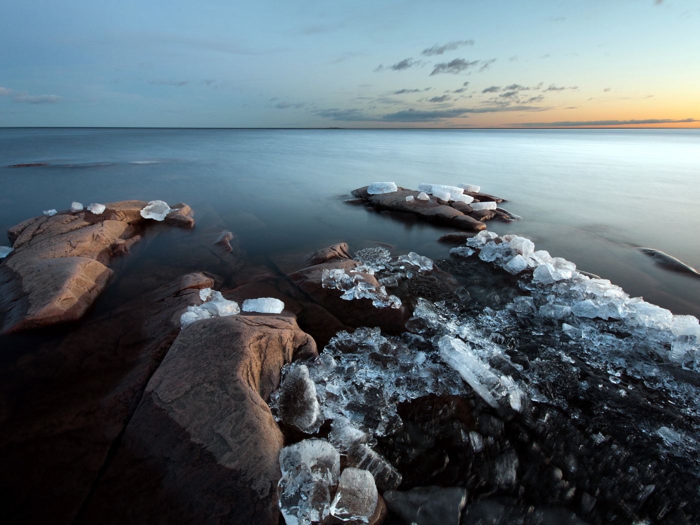 Куски льда на камнях у берега