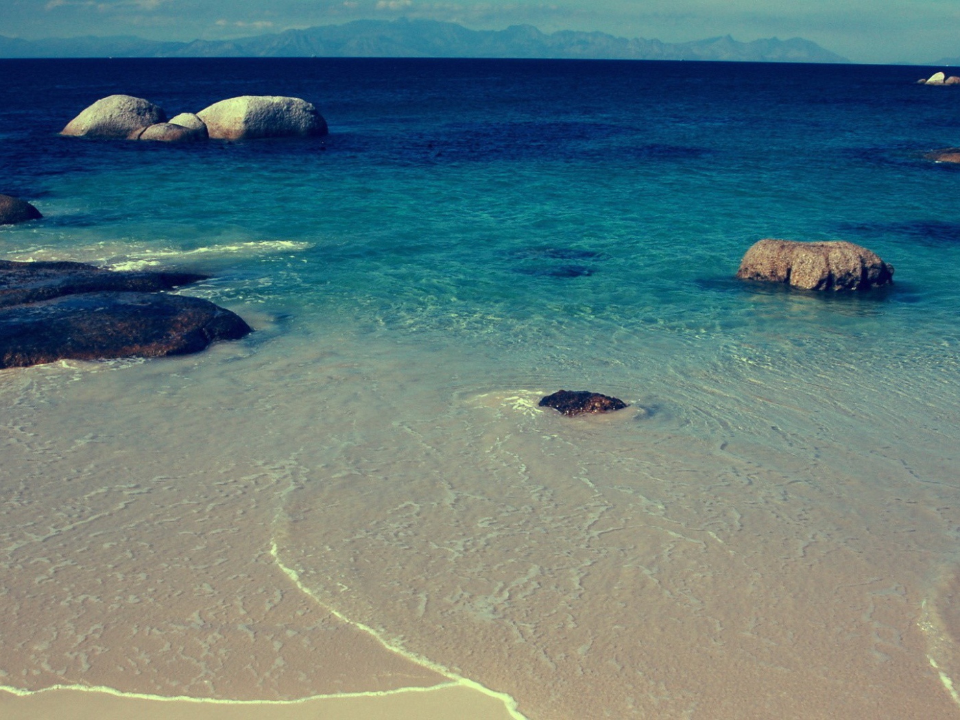 Камни в синей воде у берега моря