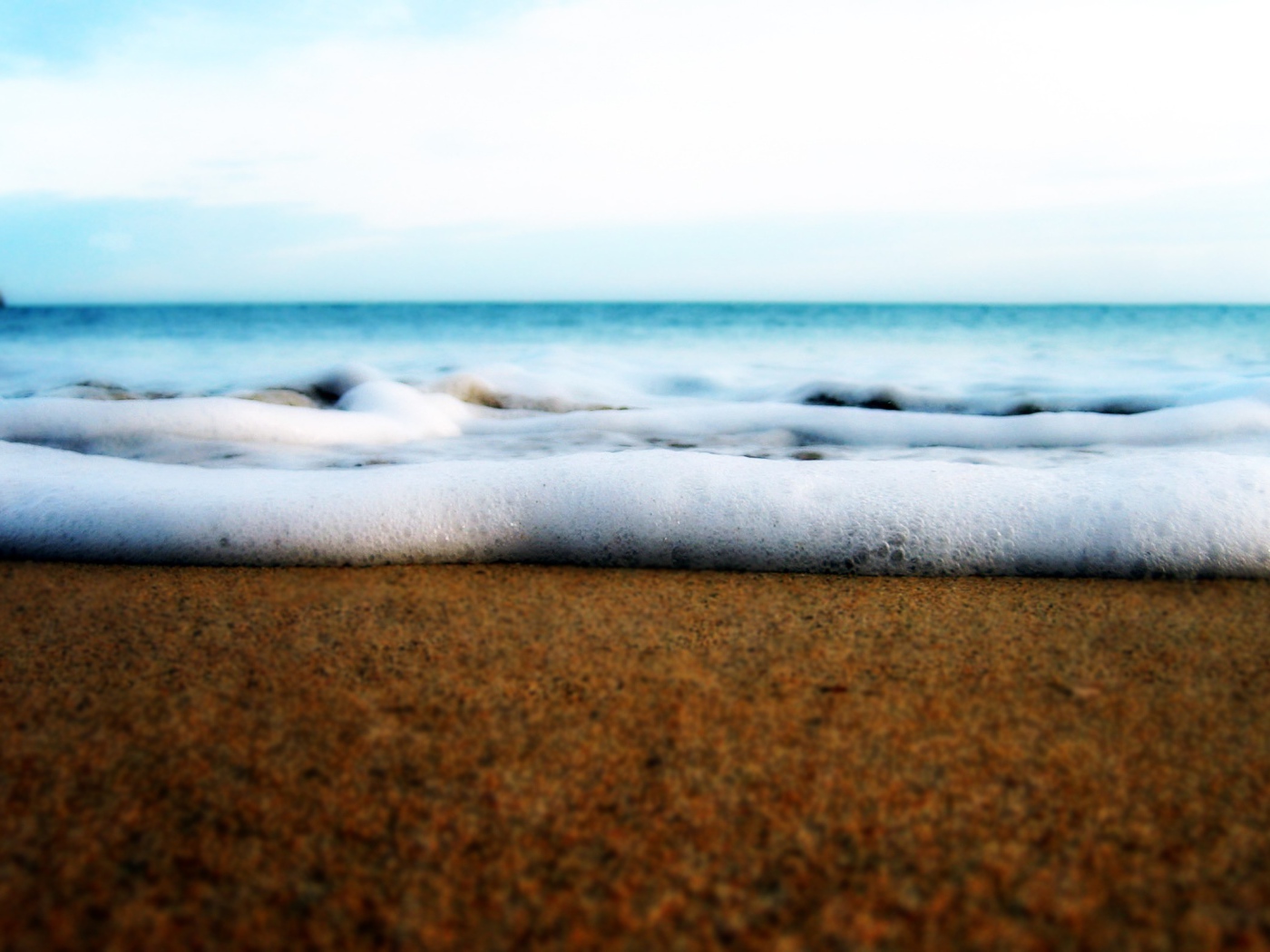 Белая пена волны у берега