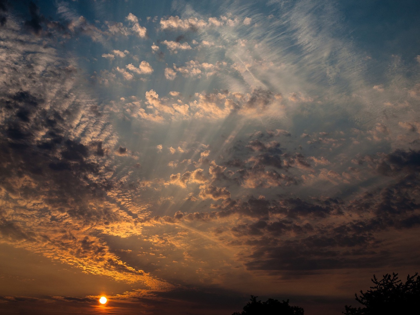 Солнце на закате освещает перистые облака