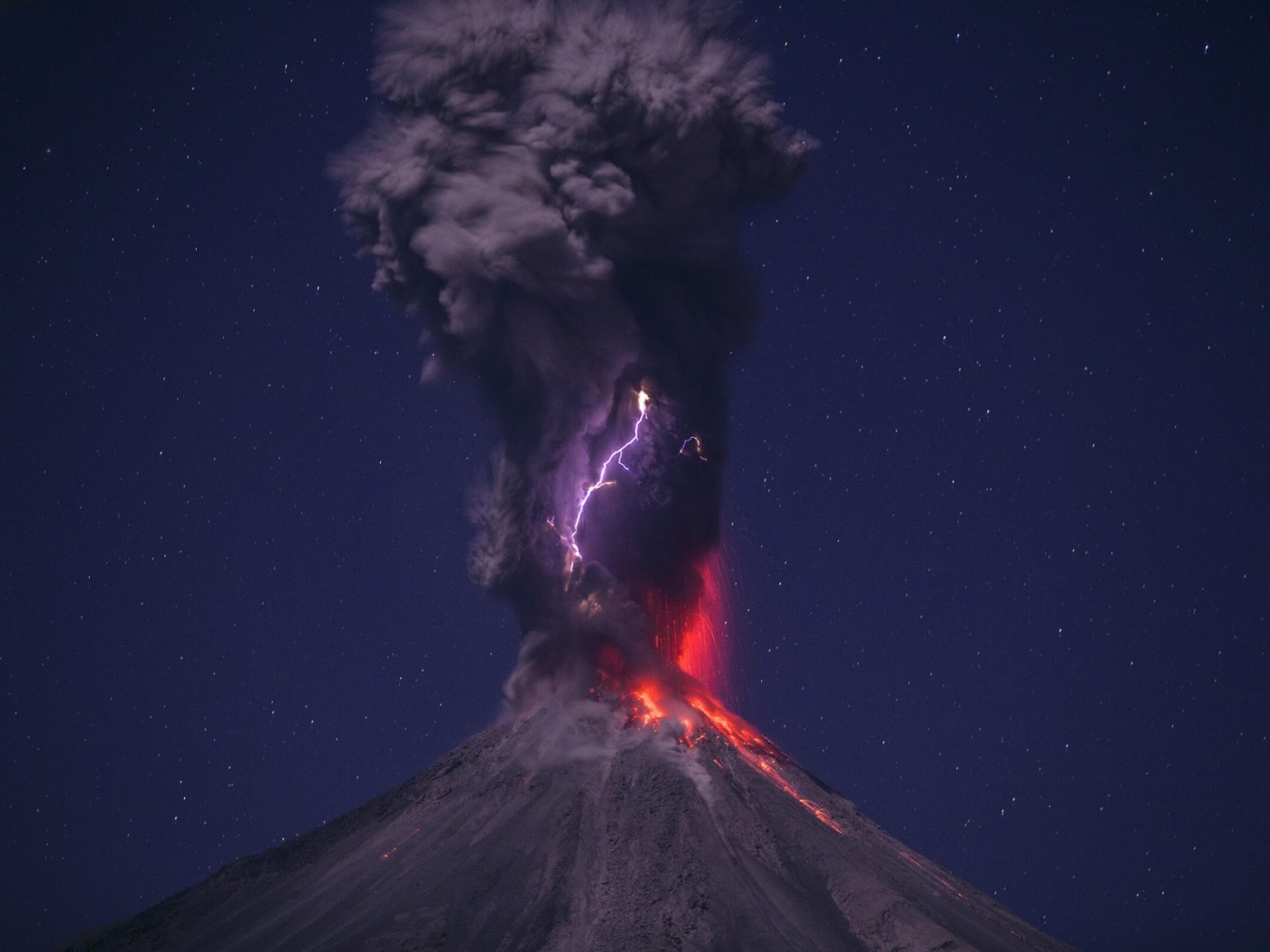 Выброс пепла из вулкана на фоне звездного неба