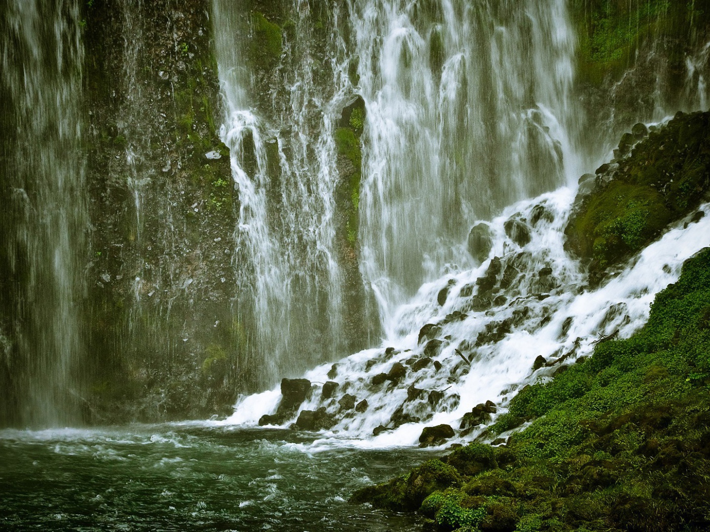 Брызги и потоки водопада среди зелени