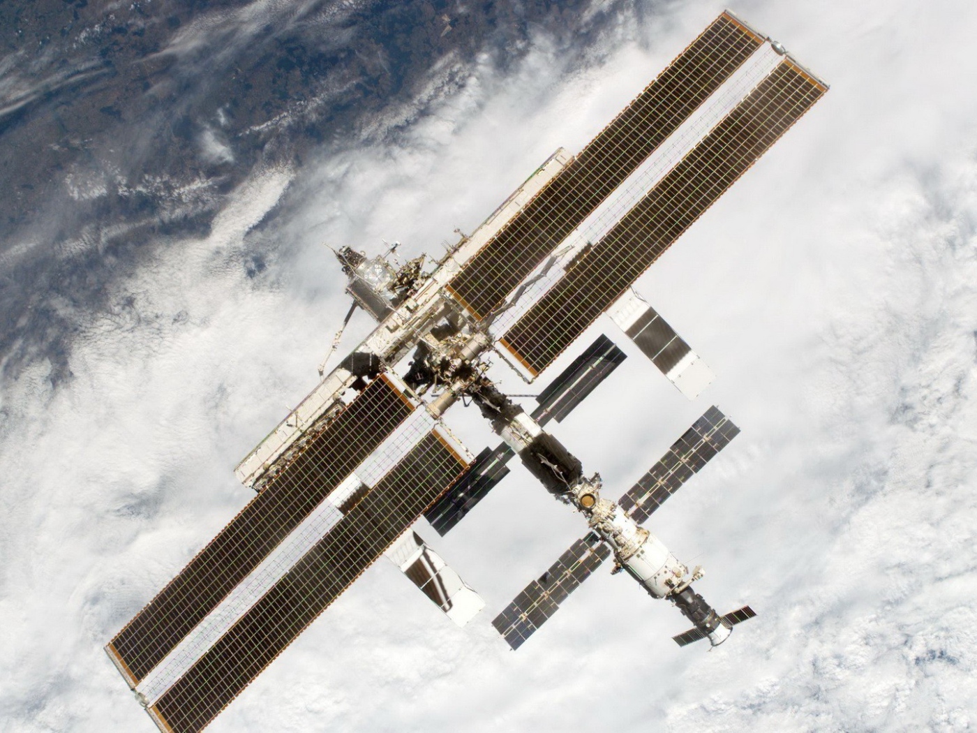 МКС пролетает над облаками на Земле