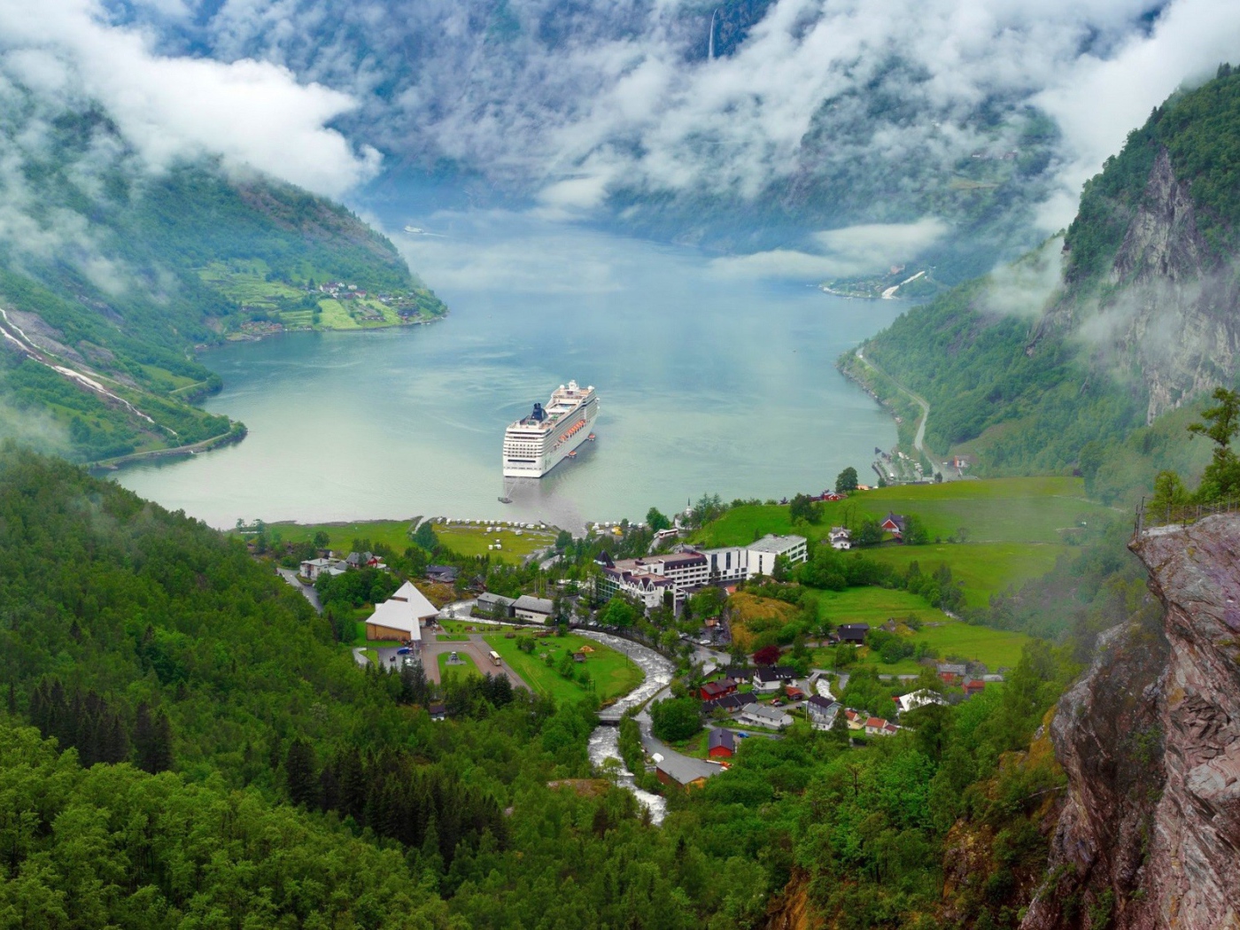 Круизный корабль у прибрежной деревушки в Норвегии